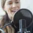 Lady warming up voice behind mic